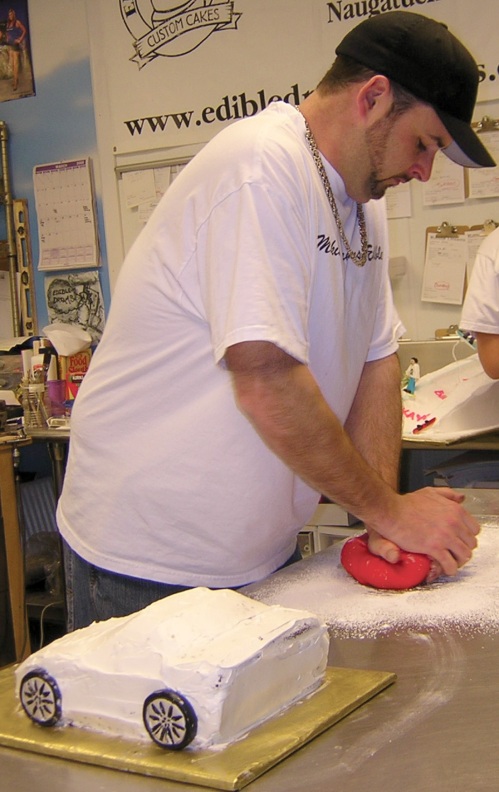 Ed Hughes works a ball of red fondant that will be used to cover a Corvette cake at Edible Dreams Custom Cake Shop and Bakery in Naugatuck.